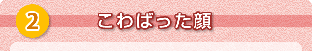 ②こわばった顔